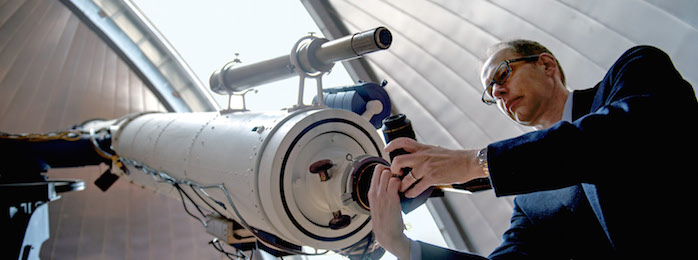 man adjusting telescope eyepiece